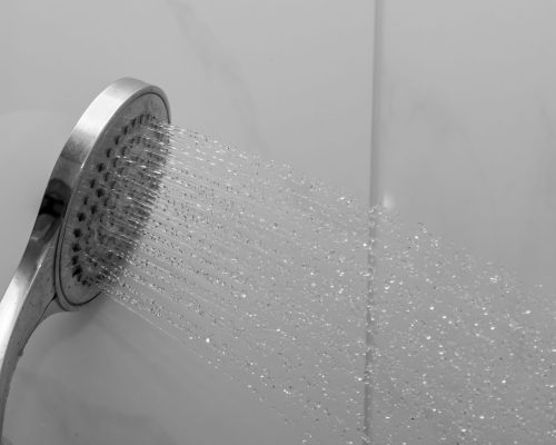 Duschkopf mit fliessendem Wasser - Spritzendes Wasser - Hartes Wasser im Haus